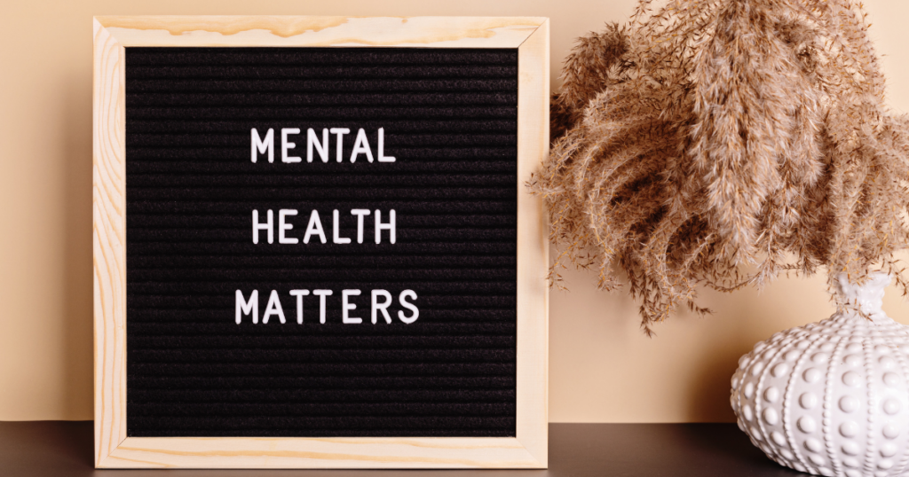 Letter board reads 'MENTAL HEALTH MATTERS' with a beige background and dried grasses in a white vase to the right.